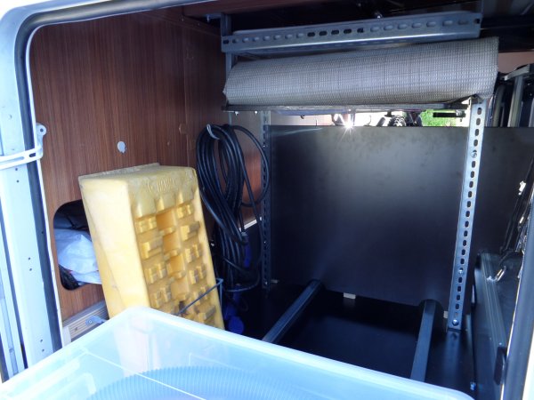 Bakom lådorna finns utematta, längre kabel, toavagn o vattenkanna.JPG